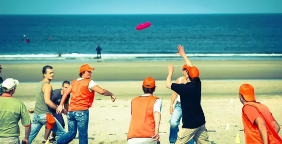 Groepsactiviteit: Frisbee spelen op het strand